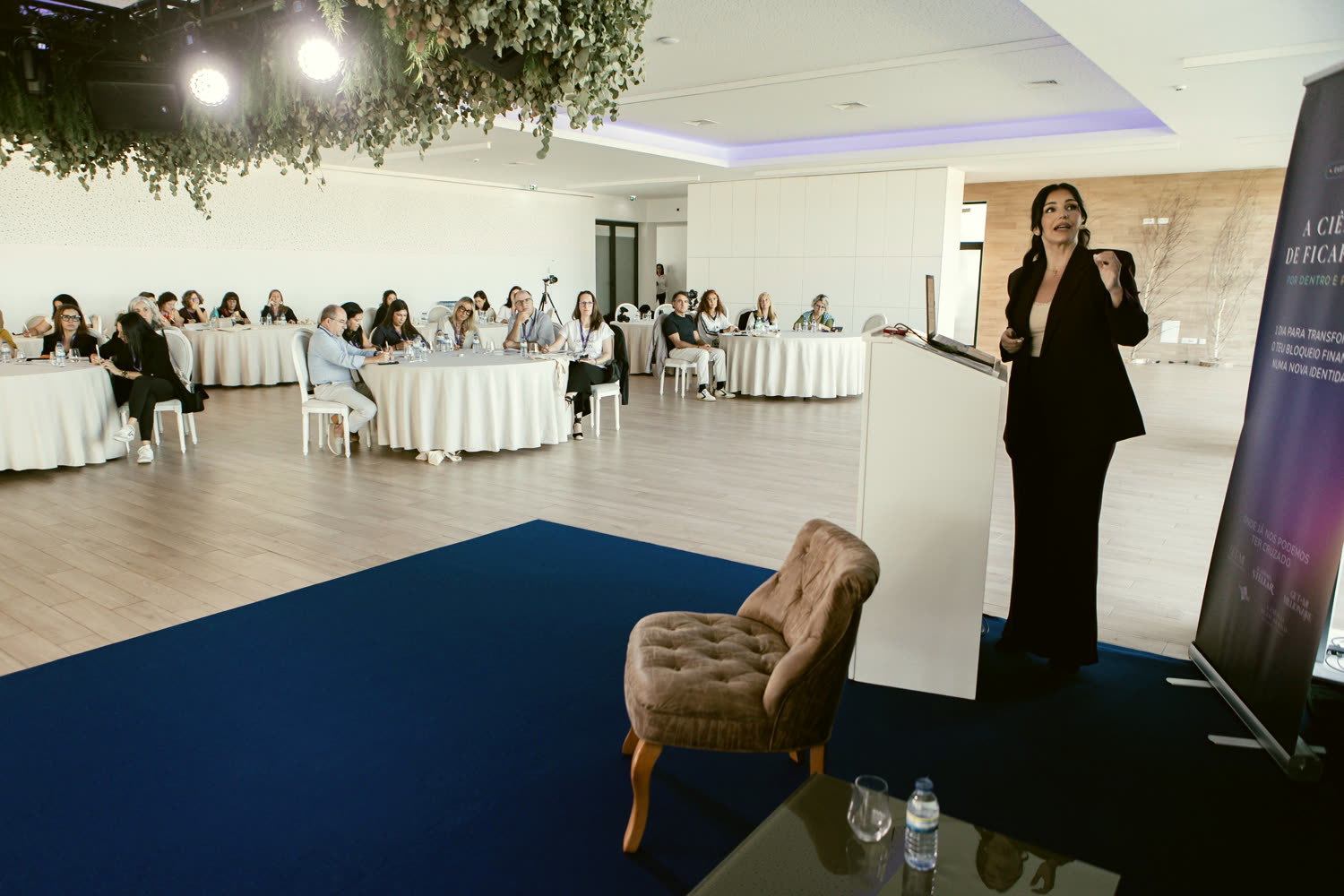 Diana Stellar em palco, perante uma sala de empresárias